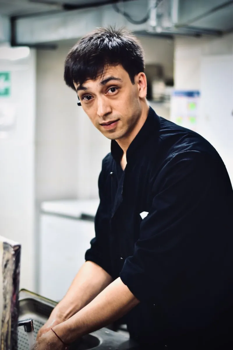 black, career, chef, closeup, dark shirt, dim light, indoor, job, kitchen, kitchen background, man, plumber, portrait, profession, professional, restaurant, restaurant_service, serious, shelves, shirt, sink, under, work, working, young